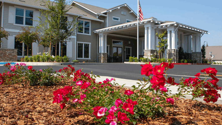 Bright pink flowers blooming in the landscaping of a commercial building.